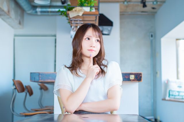 上を向いて何かを考える女性
